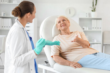 Obraz premium Senior woman with doctor talking about vaccination in clinic