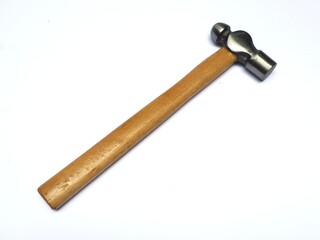 A ball-peen hammer with a wooden handle and polished steel head lies diagonally on a white background. A primary hand tool used for metalwork and general DIY projects.