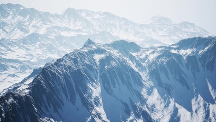 Fototapeta premium Majestic mountains rising sharply against a clear blue sky, cloaked in a pristine layer of snow. The tranquil landscape invites adventure and exploration during a sunny winter day.
