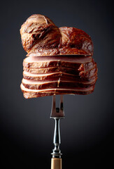 Sliced smoked gammon on a black background.