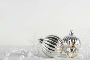 Christmas baubles with garland and snowflakes on white background