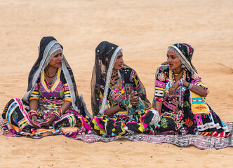 Vibrant Banjara Gypsy Women in Traditional Dress and Ornate Jewelry Sitting on Pushkar Desert Sand, Rajasthan, India, 28 Jan 2024