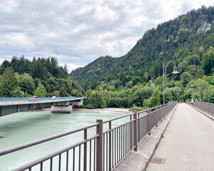 Obraz premium Journey to the Alpine forests on bridges crossing the blue waters of the Lech River.
