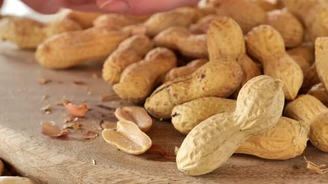 Peanuts. Groundnuts. Peanut cleaning process.Close-up of fingers peeling peanut kernels from their shells.A delicious and healthy snack. Peanut butter ingredient.Plant-based protein source. 4k footage