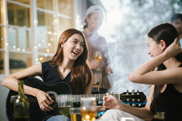 Group of friends enjoying barbecue and wine together in a cozy outdoor party, smiling and chatting in a cheerful atmosphere.