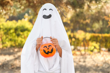 Teenage boy dressed as ghost for Halloween in park