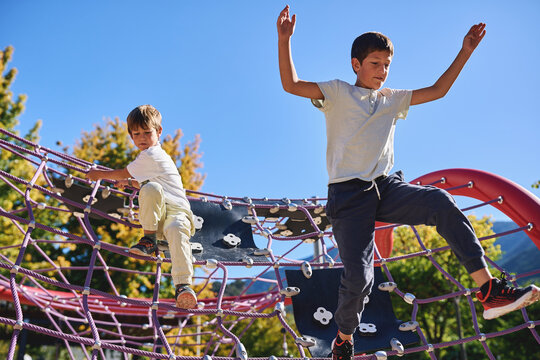Two brothers having fun on a playground climbing structure