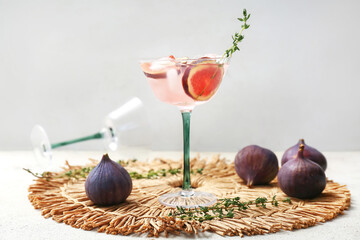 Glass of fresh fig lemonade on white grunge table, closeup