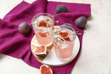 Composition with glasses of fresh fig lemonade on white grunge background, closeup