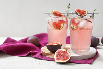 Composition with glasses of fresh fig lemonade on white grunge table, closeup