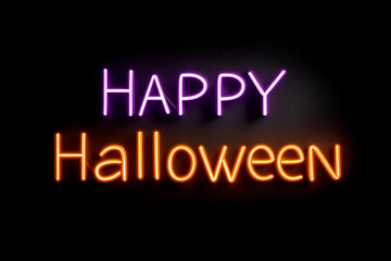 A vivid neon sign reading Happy Halloween in purple and orange against a dark background, bright and festive.