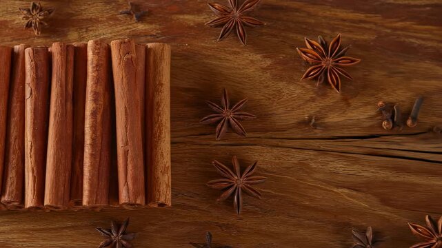 Spices cinnamon sticks and star anise on brown wooden surface