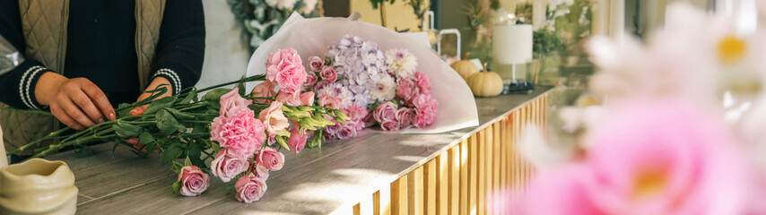 Florist arranging a beautiful bouquet of pink and purple flowers