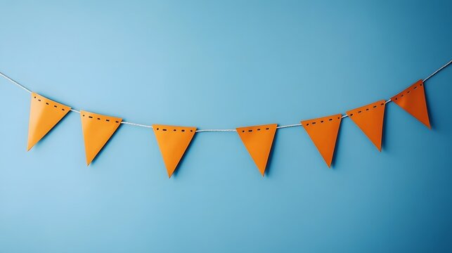 Festive orange triangular party banner hanging on light blue wall background
