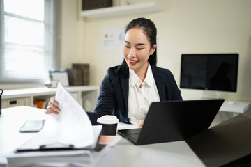 Businesswoman working in Stacks of paper files for searching and checking unfinished document...