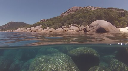 Underwater rock formations meet the sky in crystal clear ocean water view