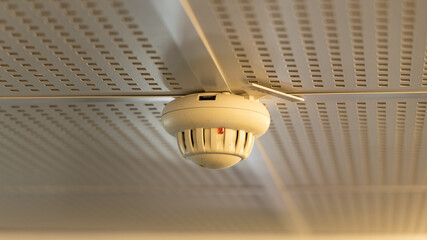 Détecteur de fumée installé au plafond d'un bâtiment.