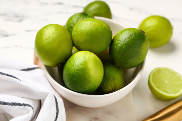 Bowl with fresh ripe limes on white background, closeup