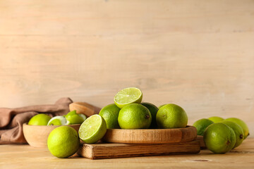 Plate with fresh ripe limes on wooden background