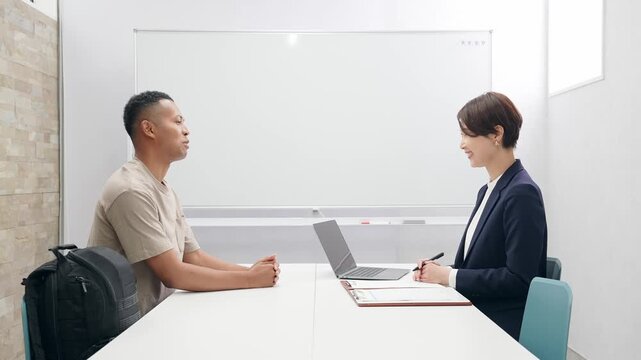 面談する黒人男性と日本人女性スタッフ