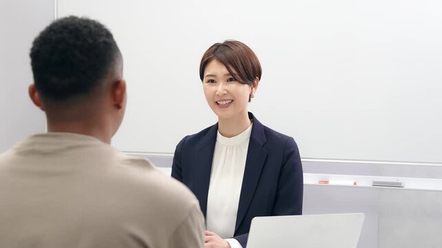 黒人男性と面談する日本人女性スタッフ