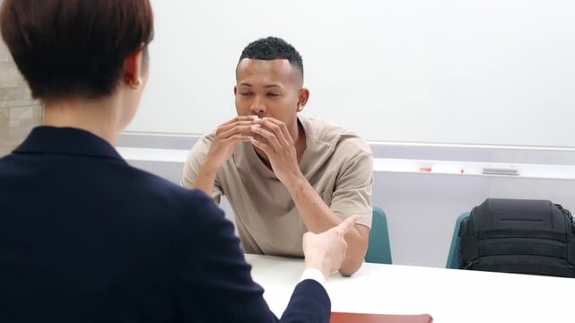 A black man and a Japanese female staff member signing documents