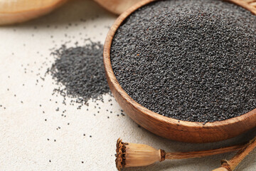 Wooden bowl with poppy seeds on white background, closeup
