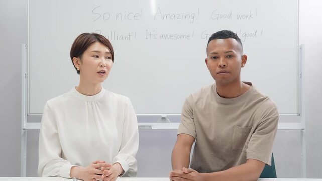 教室で授業する黒人男性と日本人女性