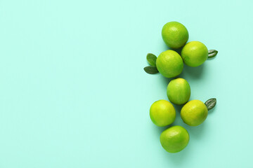 Fresh ripe limes and leaves on turquoise background