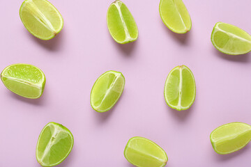 Pieces of fresh ripe limes on lilac background