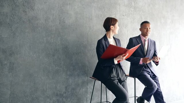 おしゃれな部屋で会話する黒人男性ビジネスマンと日本人女性スタッフ