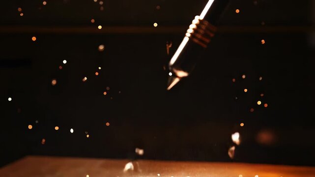 Pen impacting surface, creating explosion of shattered pieces