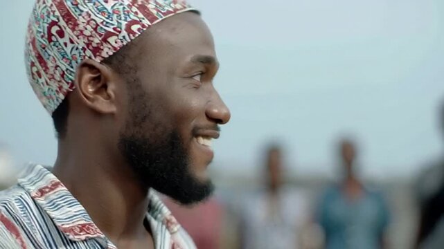 Smiling man in colorful attire, celebrating outdoor festival, capturing joy and cultural pride, African heritage, unity, and connection