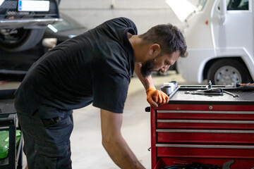 Mechanic working at garage searching for tools