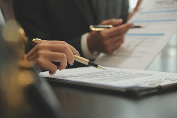 Business and lawyers discussing contract papers with brass scale on desk in office. Law, legal services, advice, justice and law concept picture with film grain effect