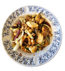 Isolated photo of Stir-fried chicken with cashew nuts, dried chilies, onions, and vegetables—served on a floral-rimmed plate in savory glossy sauce.