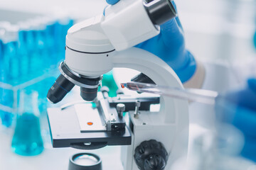 medical or scientific researcher researching and experimenting Multi-colored solution, vial and microscope In the laboratory or in the laboratory by wearing blue gloves and white clothing completely.
