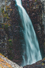 Njupeskär, Sweden's largest waterfall, cascades dramatically amidst autumn colors and rocky terrain