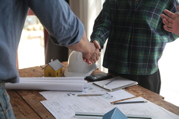 Engineer and contractor join hands after signing contract,They are having a modern building project together. successful cooperation team concept