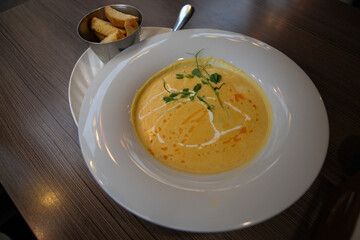 Creamy cheese soup with breadsticks in a white bowl. Autumn seasonal cream soup. Lunch, dinner. Copy space.