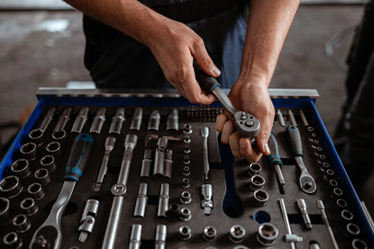 Skilled mechanic organizing tools in workshop for efficient repairs and maintenance tasks - Powered by Adobe