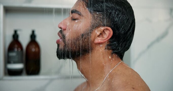 Man, shower and washing face in home bathroom for cleaning, wellness and cosmetic products. Male person, house and running water in morning for skincare, splash and fresh body with profile of guy