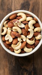 Fototapeta premium Delicious Mixed Nuts in Bowl, Almonds and Cashews on Wooden Background