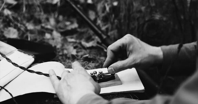 Historical Re-enactment Black And White Video. Russian Soviet Infantry Red Army Soldier In World War II using Russian Soviet Portable Radio Transceiver In Trench Entrenchment In Spring Autumn Forest