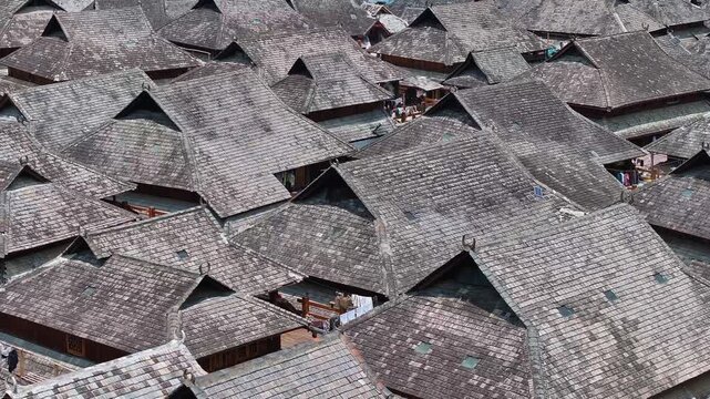 Aerial view of many tightly packed rooftops displaying a uniform gray texture across Nuogang Village, creating an abstract pattern, Nuogang Village, China.