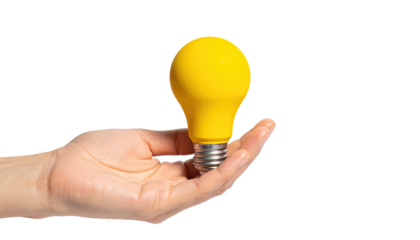 Human hand cradles a glowing yellow light bulb against a stark black backdrop