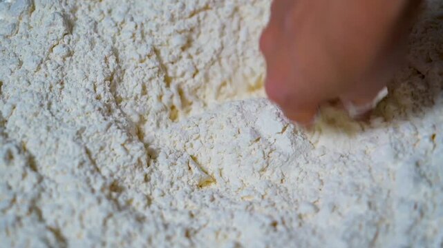 Hand makes a hole in which he will throw the egg for the genuine dough