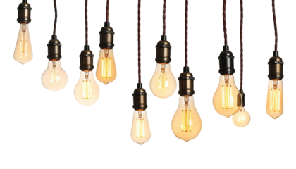 Assorted hanging light bulbs, with warm filaments, against a stark black background