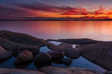 Coastal sunset with rocks and water reflections in Gothenburg, Sweden during twilight