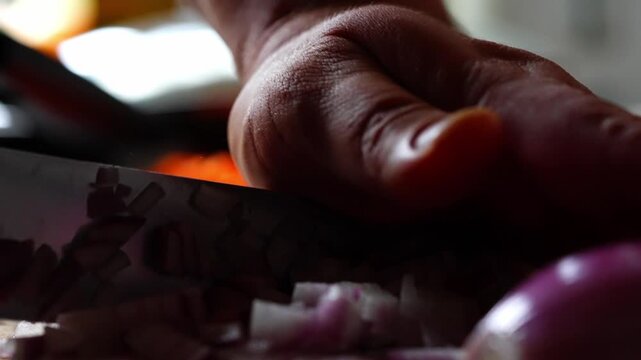 Close of sharp knife slicing red onion cleanly, purple layers separate on board